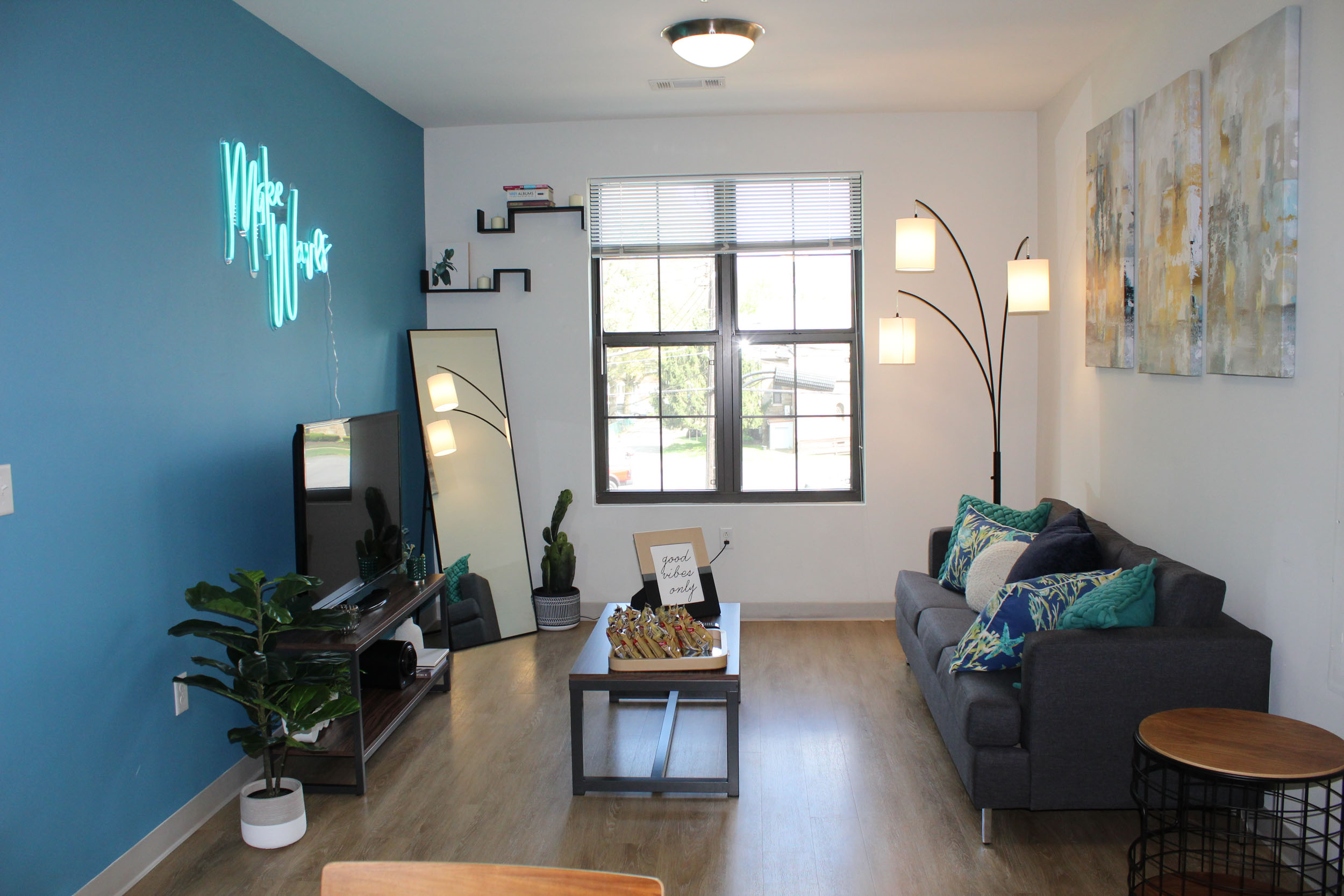 Stylish living room with neon sign accent wall and home decor